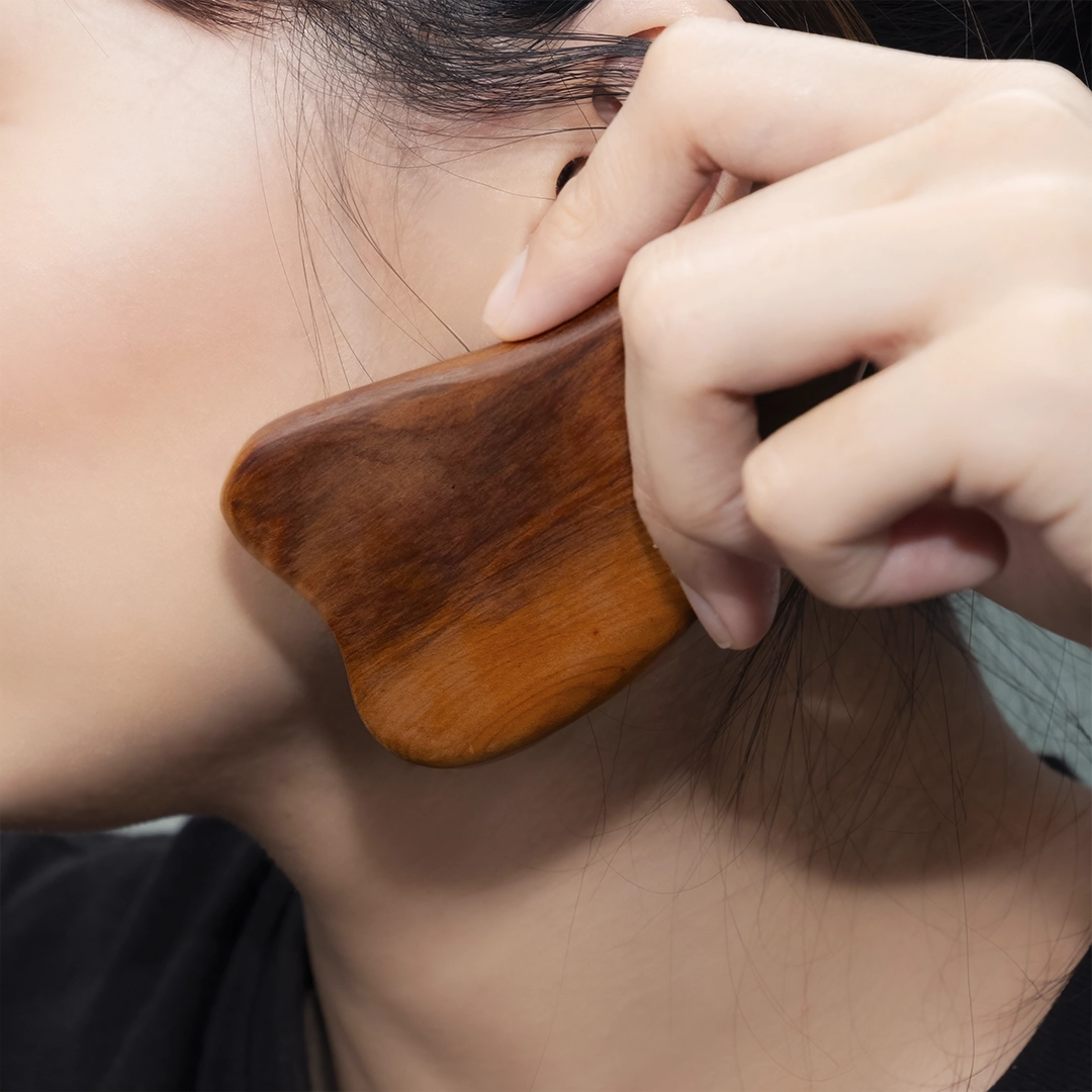 臉部刮痧按摩示意，配合護手霜或精油提升輪廓線，居家 SPA